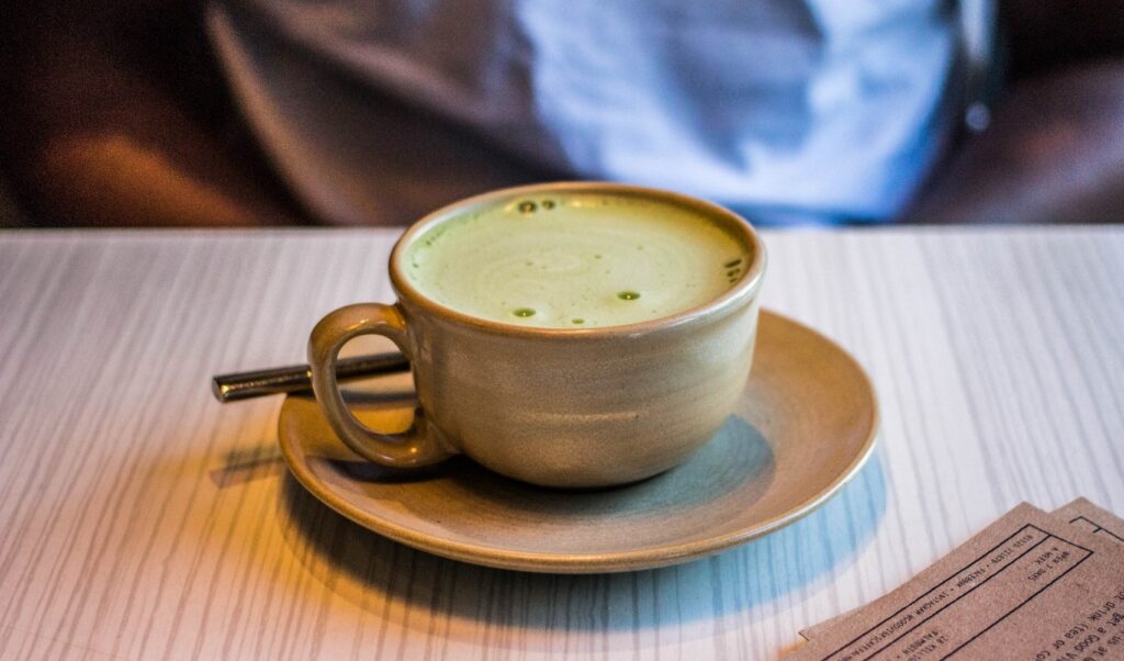 A cup of green tea on a table.