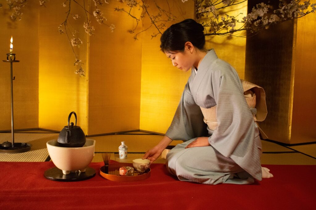 A woman serving tea on a red capet.