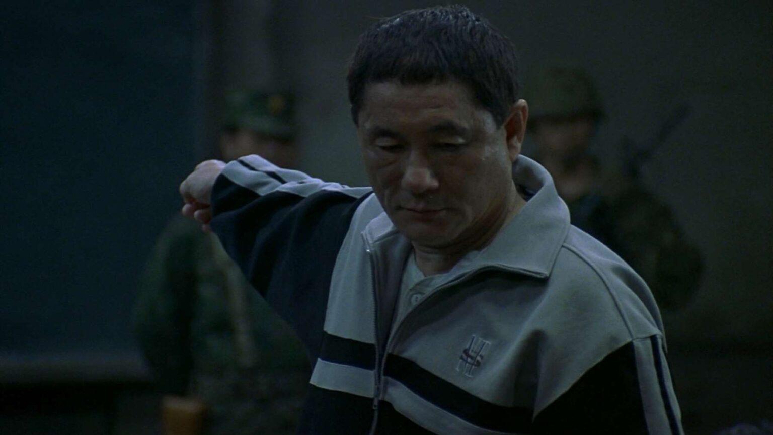 man in a blue and grey tracksuit, pointing