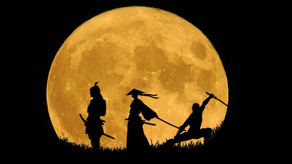 three figure silhouettes against a bright yellow moon
