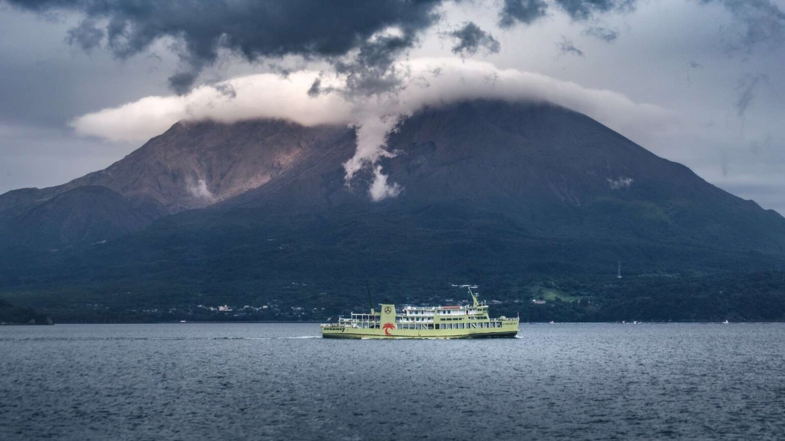 green boat in front of mountains